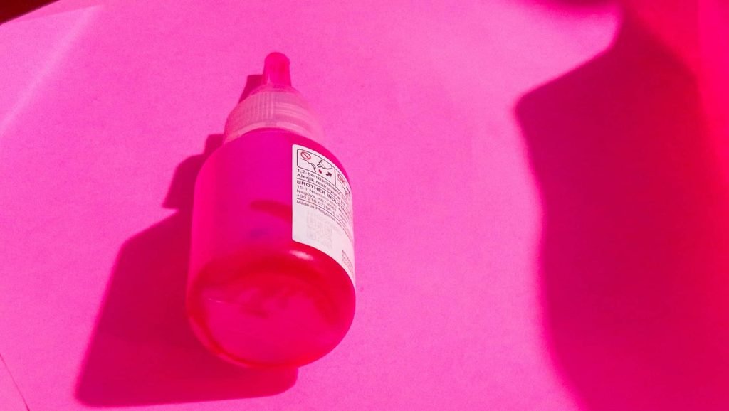 a pink bottle is shown in a pink light
